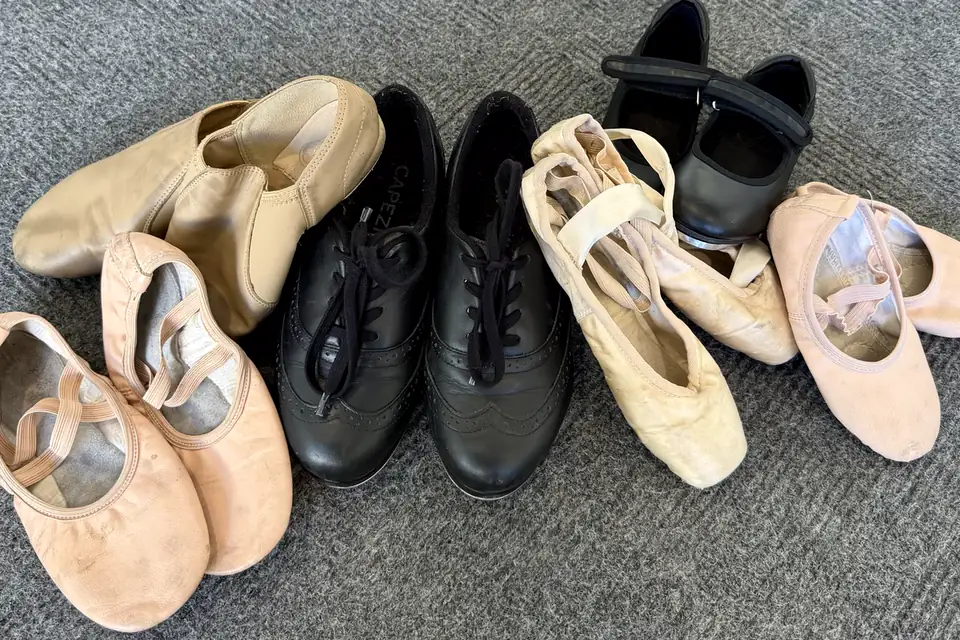 An assortment of ballet slippers, tap shoes, and jazz shoes at the studio