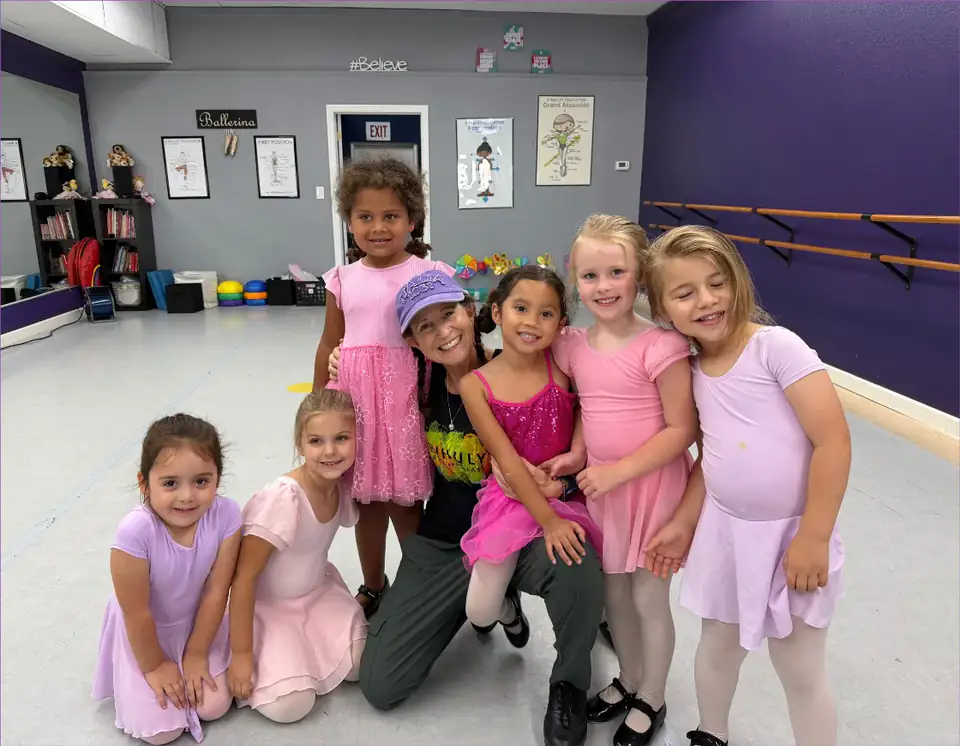 A teacher and young dancers smiling together in the Serendipity studio